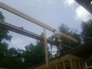 Carpenter setting a ridge beam over a new addition frame — Ice Dam Removal by Roofing Brothers in West Hempstead