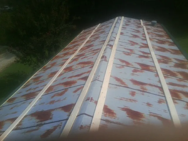 Rusted metal roof panels with new wood purlins before replacement — Storm Damage Roof Repair in West Hempstead by Roofing Brothers