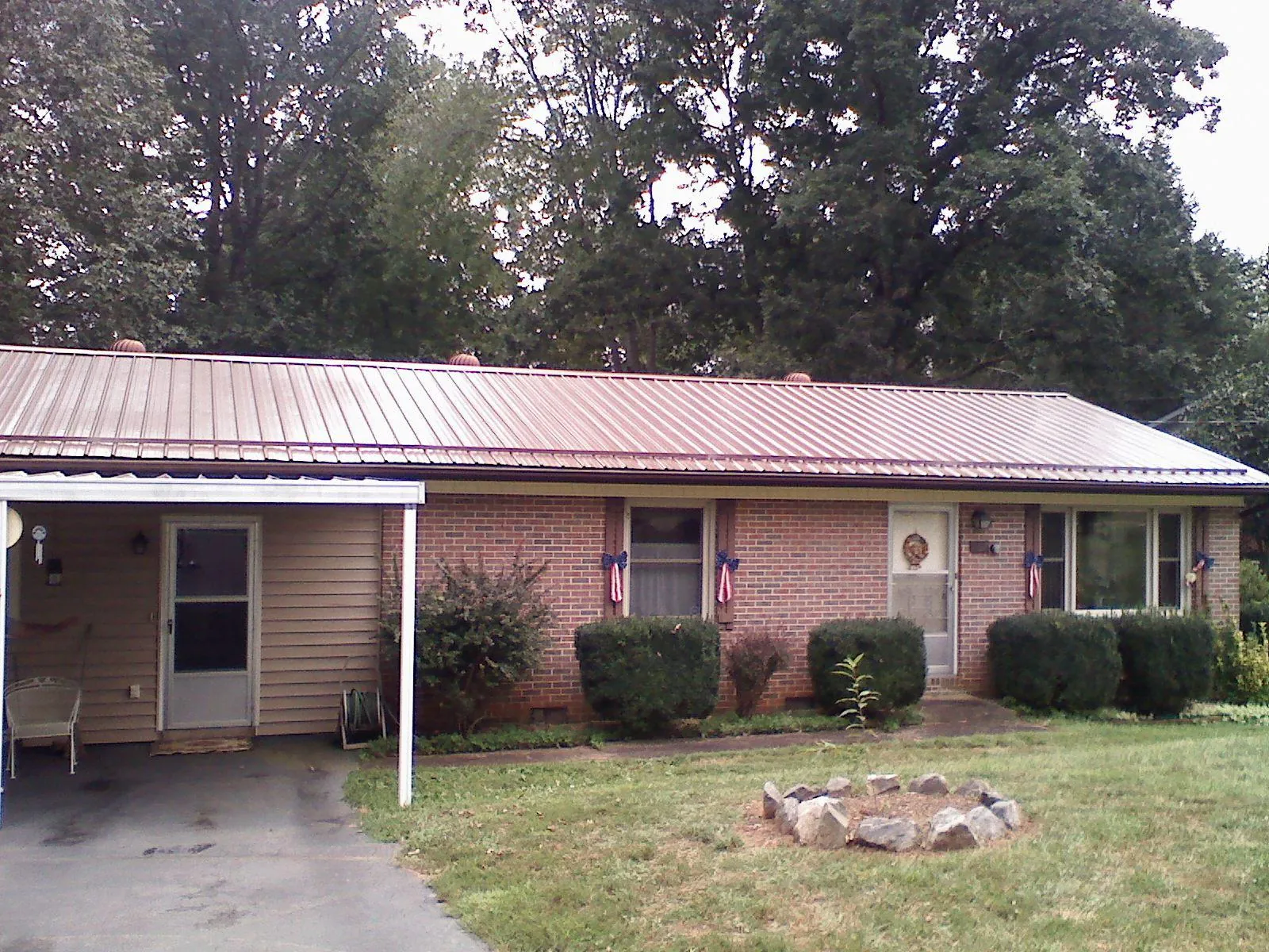 Bronze metal roof and carport on a brick ranch home — Roof Repair work by our crew in West Hempstead